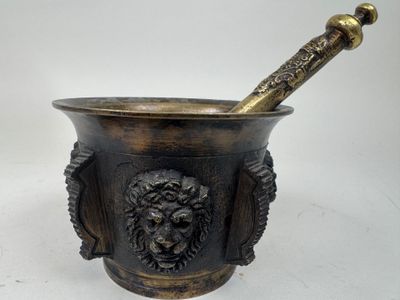 brass mortar with lion head and pestula in it