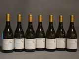 six bouteilles de vin sont alignées sur une table