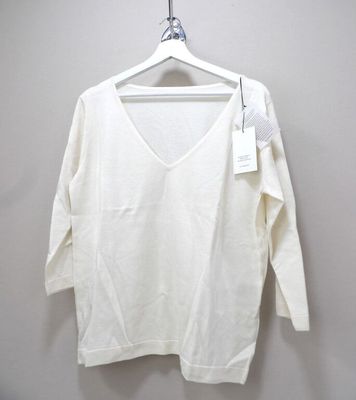 the white shirt is hanging on a hanger on the wall