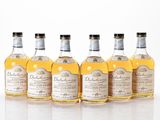 four bottles of different types of alcohol are lined up in a row