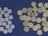two different types of coins on a blue surface