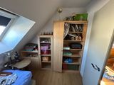 a room with a bed and a book shelf in it