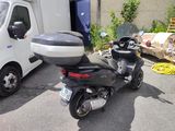 a motor scooter parked in a parking lot next to a truck