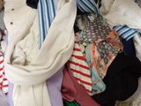 a pile of clothes that is on a bed