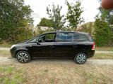 a picture of a small black car parked on a dirt road