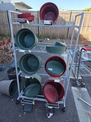 a rack with many different colored pots and pans on it