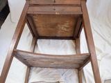 a wooden chair that has a wooden seat on it