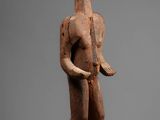 an image of a wooden statue of a man holding a knife