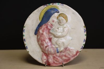 une assiette sur laquelle est représentée une femme tenant un bébé dans ses bras