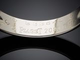 a close up of a silver bracelet with a date on it