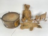 trois oursons en peluche et un tambour posés sur une surface blanche