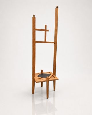 a wooden chair with a black seat on a white surface