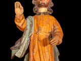 wooden statue of a man with a beard and a robe holding his hand up