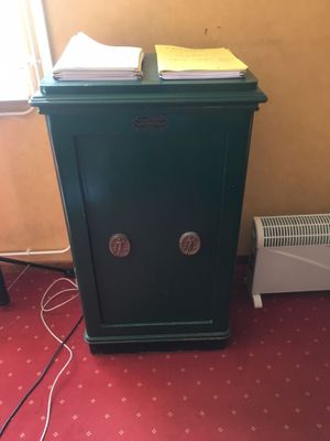 un coffre-fort vert posé par terre à côté d'un radiateur