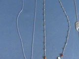 several different necklaces are displayed on a blue surface
