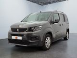 La camionnette grise est garée dans une grande pièce d'un immeuble.
