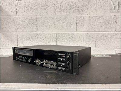 une vieille chaîne hi-fi posée sur une table devant un mur de briques