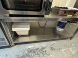 une personne debout devant un four dans une cuisine