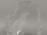 une sculpture en verre représentant un oiseau perché sur une branche
