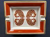 an orange and white plate with two birds on it