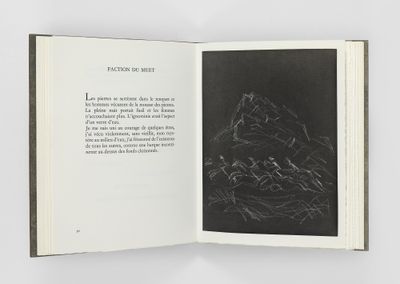 un livre ouvert sur lequel figure un dessin en noir et blanc représentant une montagne