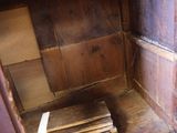 a toilet in the corner of a room with wood floors