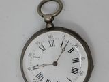 a silver pocket watch with roman numerals on the face