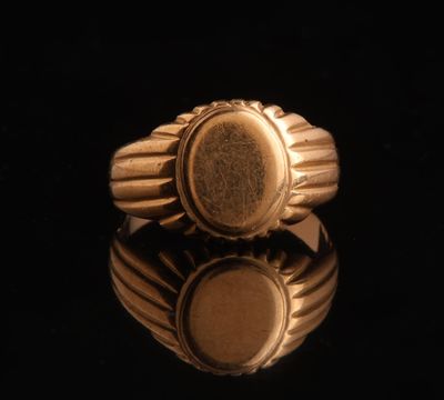 a close up of a gold ring on a black surface
