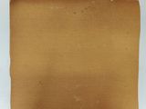 an old piece of brown paper with torn edges on a white surface