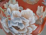 a vase with a floral design on it sitting on a stand