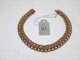 gros plan d'un bracelet en chaîne en or avec une étiquette de prix