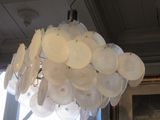 a chandelier made out of plastic plates hanging from the ceiling
