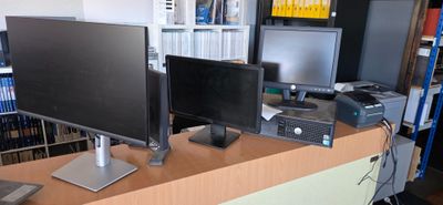 un bureau sur lequel sont posés deux écrans et un ordinateur portable