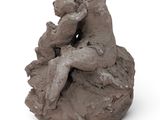 a clay sculpture of a man and a woman sitting on a rock