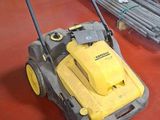 a yellow and black sweeper on the floor in a store