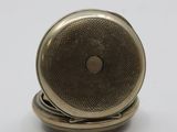 an image of a close up of a pocket watch on a white surface