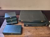 a lot of green leather boxes on a wooden table