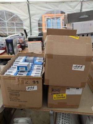 plusieurs cartons d'eau posés sur une table dans une tente