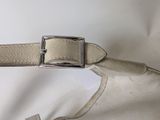 a white purse with a silver buckle on it
