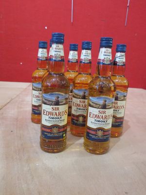 six bouteilles de whisky posées sur une table, avec un mur rouge en arrière-plan