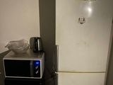 un réfrigérateur blanc et un micro-ondes dans une petite pièce