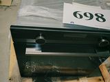 un four noir posé sur une palette dans un entrepôt