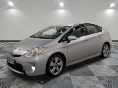 une photo d'une Toyota Prius argentée garée sur un sol à damier