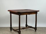 une petite table avec un plateau et des pieds en bois, posée sur un sol recouvert de moquette