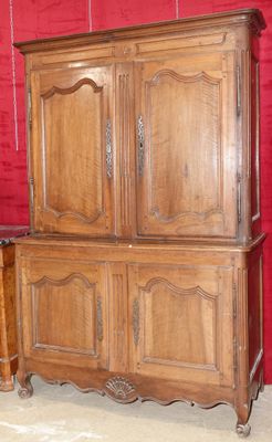 une grande armoire en bois avec un mur rouge en arrière-plan