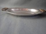 a silver plate with a wooden handle on a table