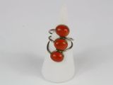 a close up of a ring with three red beads on it
