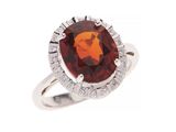 gros plan d'une bague avec une pierre rouge entourée de diamants