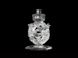a clear glass bottle with a silver top on a black background
