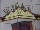 a gold and red crown on the floor next to a purse